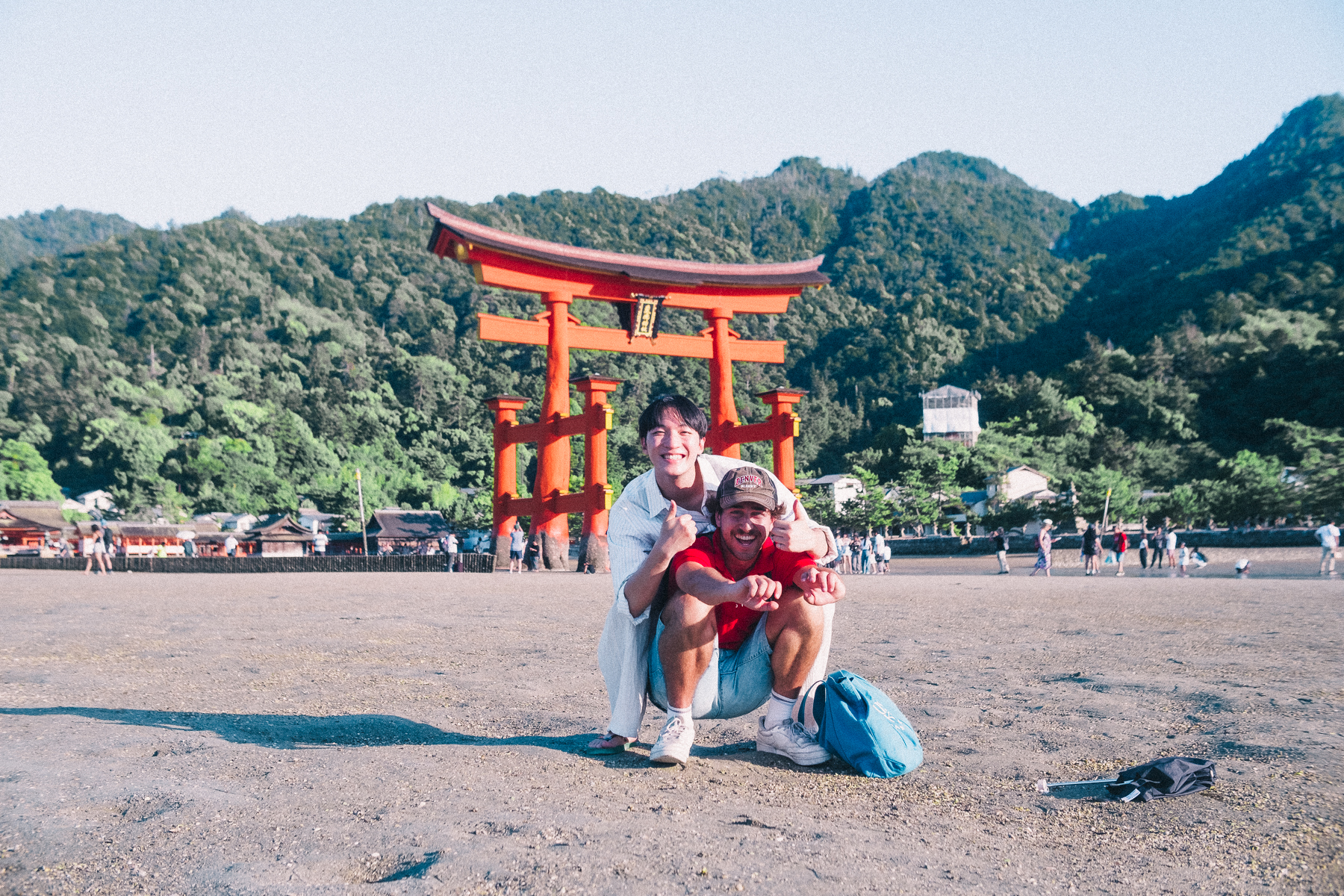 Santo posing in front of a traditional Japanese torii gate in Miyajima